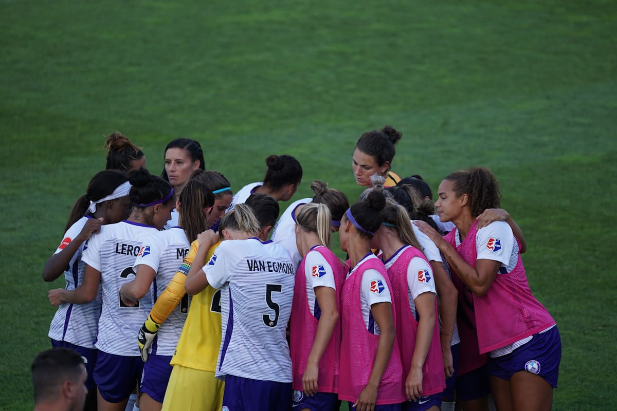 Soccer team huddling on the pitch before a match